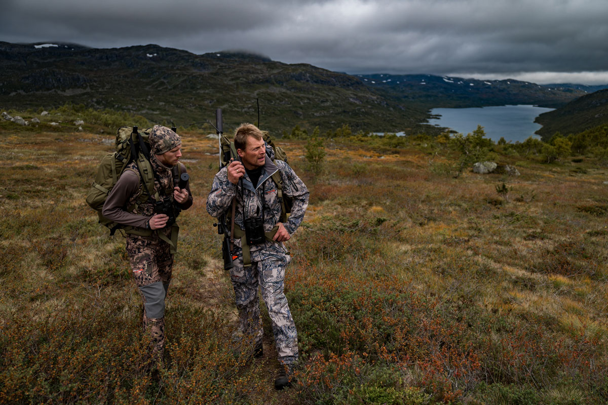 Two hunters in camouflage clothing stand in the wilderness of Norway