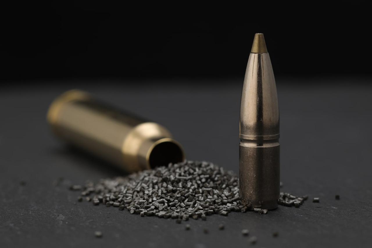 An image of a rifle cartridge, divided into its essentials components such as case, propellant powder and projectile